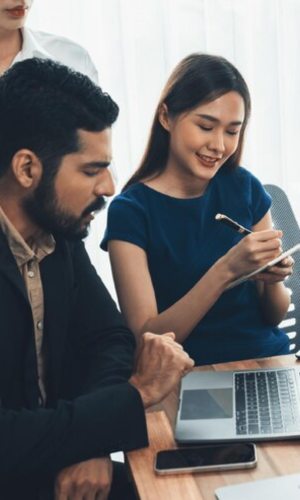 A group of people works together on laptop, concentrating business analysis to improve over business