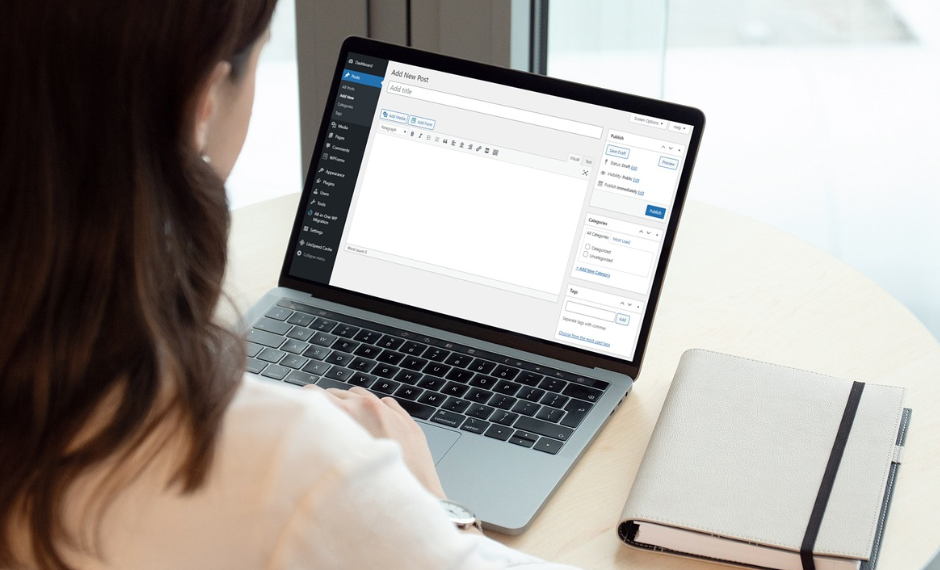 A woman is working on a laptop with a Word page, creating and managing content for a website