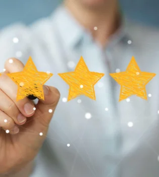 The ratings & reviews writing services are implied by a woman painting stars in yellow on a glass