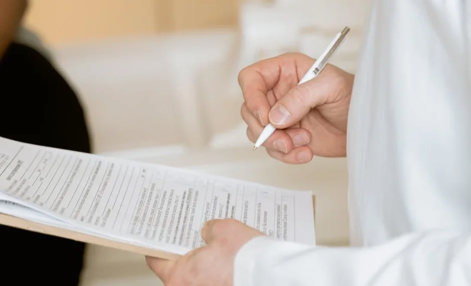 A person is checking on a medical report to write in clear language regarding patient details & facts.