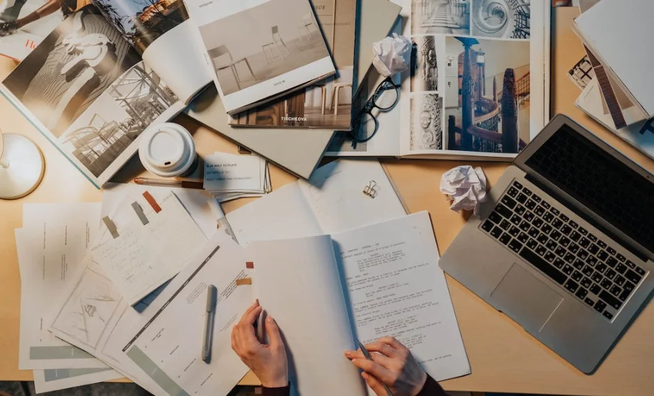 A person is sitting at a desk, surrounded by documents, offering white paper services for businesses.